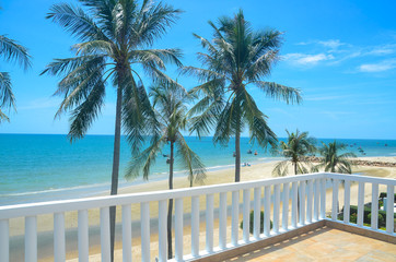 Exotic tropical vibrant coastal waterscape with palm trees in a blue sky over ocean water. Thailand.