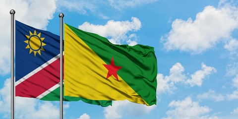 Namibia and French Guiana flag waving in the wind against white cloudy blue sky together. Diplomacy concept, international relations.