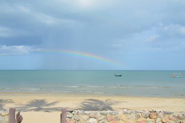  Tropical pastel coastal rainbow landscape waterscape with a blue sky over ocean water. Huay Yang, Thailand.