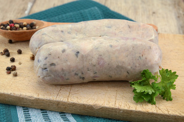 raw andouillette on a wooden board resting on a wooden table