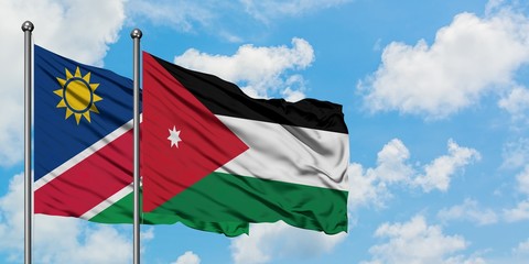 Namibia and Jordan flag waving in the wind against white cloudy blue sky together. Diplomacy concept, international relations.