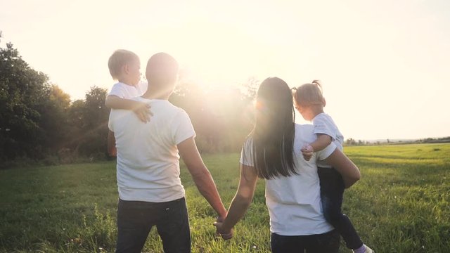 happy family funny walking go for are hold hands a teamwork Silhouette. happy children father and little boy girl with mother family at sunset. mom dad and son walk mom daughter and son in white t