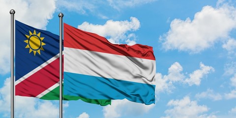 Namibia and Luxembourg flag waving in the wind against white cloudy blue sky together. Diplomacy concept, international relations.
