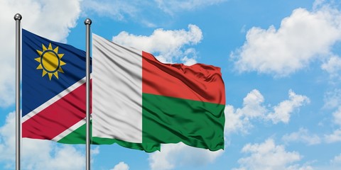 Namibia and Madagascar flag waving in the wind against white cloudy blue sky together. Diplomacy concept, international relations.