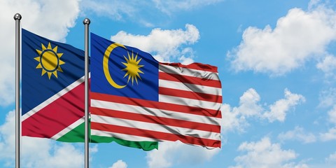 Namibia and Malaysia flag waving in the wind against white cloudy blue sky together. Diplomacy concept, international relations.