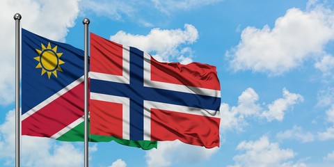 Namibia and Norway flag waving in the wind against white cloudy blue sky together. Diplomacy concept, international relations.