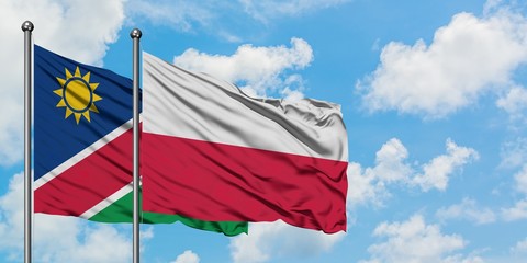 Namibia and Poland flag waving in the wind against white cloudy blue sky together. Diplomacy concept, international relations.