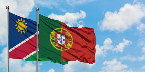 Namibia and Portugal flag waving in the wind against white cloudy blue sky together. Diplomacy concept, international relations.