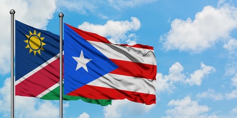 Namibia and Puerto Rico flag waving in the wind against white cloudy blue sky together. Diplomacy concept, international relations.