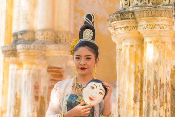 A beautiful asian model wearing dress traditional posing smile with mask face culture in ancient...