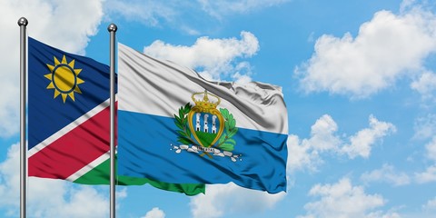 Namibia and San Marino flag waving in the wind against white cloudy blue sky together. Diplomacy concept, international relations.