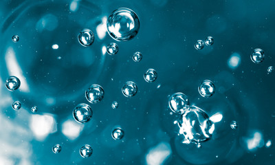 Bubbles of air on the smooth surface of blue water as an abstract background
