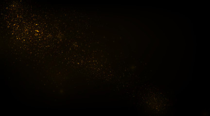 Glowing golden particles on black background	