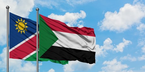 Namibia and Sudan flag waving in the wind against white cloudy blue sky together. Diplomacy concept, international relations.