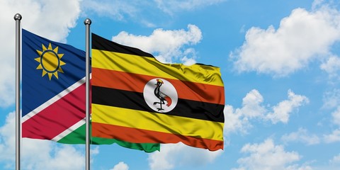 Namibia and Uganda flag waving in the wind against white cloudy blue sky together. Diplomacy concept, international relations.