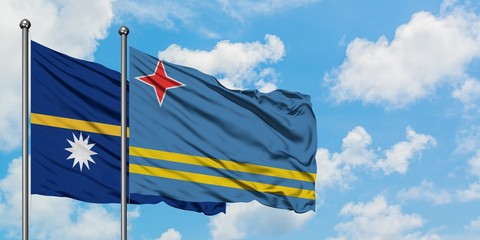 Nauru and Aruba flag waving in the wind against white cloudy blue sky together. Diplomacy concept, international relations.