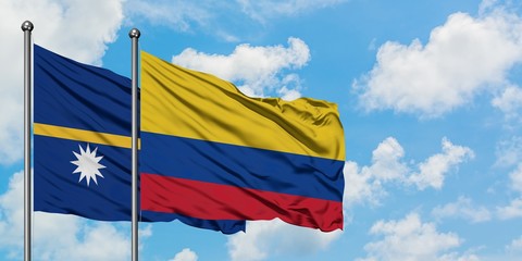 Nauru and Colombia flag waving in the wind against white cloudy blue sky together. Diplomacy concept, international relations.