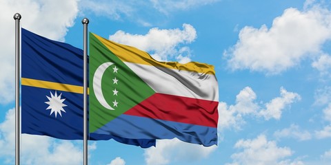 Nauru and Comoros flag waving in the wind against white cloudy blue sky together. Diplomacy concept, international relations.