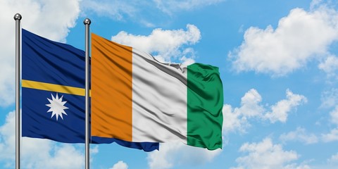 Nauru and Cote D'Ivoire flag waving in the wind against white cloudy blue sky together. Diplomacy...