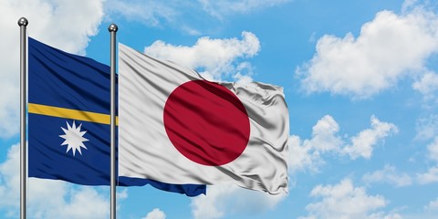 Nauru and Japan flag waving in the wind against white cloudy blue sky together. Diplomacy concept, international relations.
