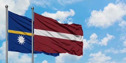 Nauru and Latvia flag waving in the wind against white cloudy blue sky together. Diplomacy concept, international relations.