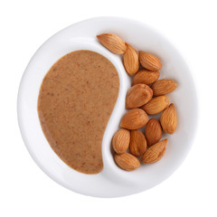 Apricot kernel butter smooth, urbech.  Natural paste from apricot kernels in white bowl isolated on white. Top view.