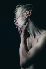 Emotional psychological metaphorical portrait of young blonde man. Black background. triple exposure