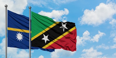Nauru and Saint Kitts And Nevis flag waving in the wind against white cloudy blue sky together. Diplomacy concept, international relations.