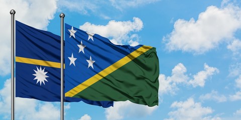 Nauru and Solomon Islands flag waving in the wind against white cloudy blue sky together. Diplomacy concept, international relations.