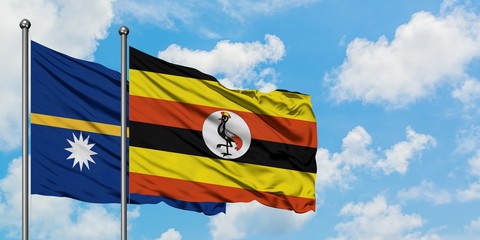 Nauru and Uganda flag waving in the wind against white cloudy blue sky together. Diplomacy concept, international relations.