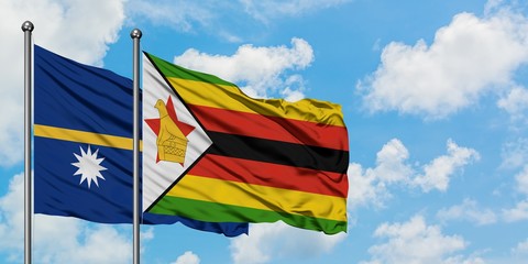 Nauru and Zimbabwe flag waving in the wind against white cloudy blue sky together. Diplomacy concept, international relations.