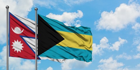 Nepal and Bahamas flag waving in the wind against white cloudy blue sky together. Diplomacy concept, international relations.