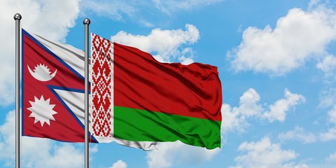 Nepal and Belarus flag waving in the wind against white cloudy blue sky together. Diplomacy concept, international relations.