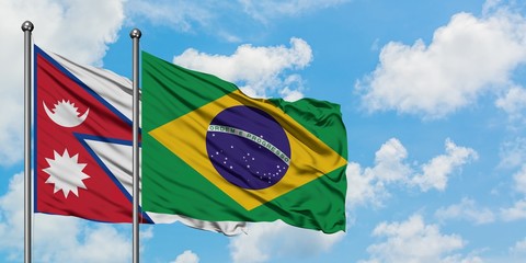 Nepal and Brazil flag waving in the wind against white cloudy blue sky together. Diplomacy concept, international relations.