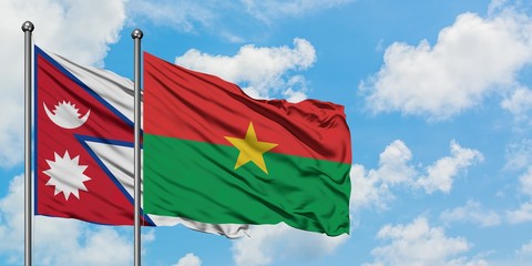 Nepal and Burkina Faso flag waving in the wind against white cloudy blue sky together. Diplomacy concept, international relations.
