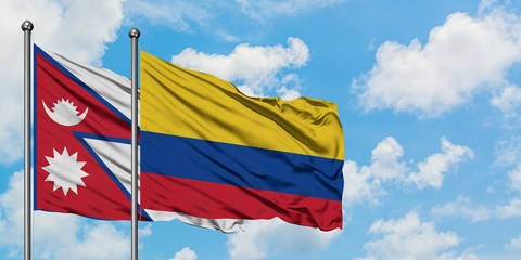 Nepal and Colombia flag waving in the wind against white cloudy blue sky together. Diplomacy concept, international relations.