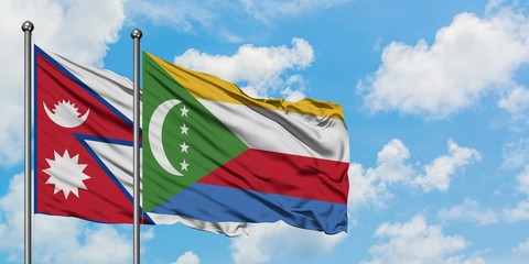 Nepal and Comoros flag waving in the wind against white cloudy blue sky together. Diplomacy concept, international relations.