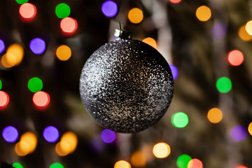 Christmas silver toy on a bokeh background. Flashing lights, new year.