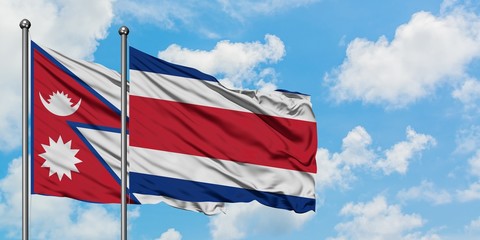 Nepal and Costa Rica flag waving in the wind against white cloudy blue sky together. Diplomacy concept, international relations.