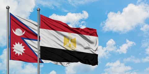 Nepal and Egypt flag waving in the wind against white cloudy blue sky together. Diplomacy concept, international relations.