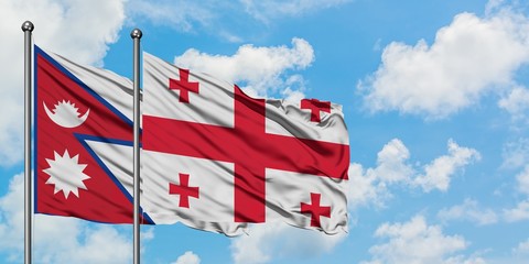 Nepal and Georgia flag waving in the wind against white cloudy blue sky together. Diplomacy concept, international relations.