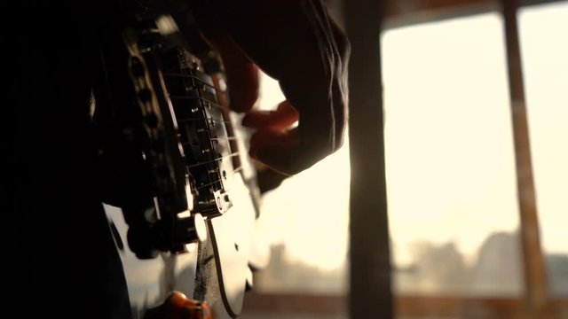 Human hand plays guitar at home