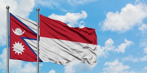Nepal and Indonesia flag waving in the wind against white cloudy blue sky together. Diplomacy concept, international relations.