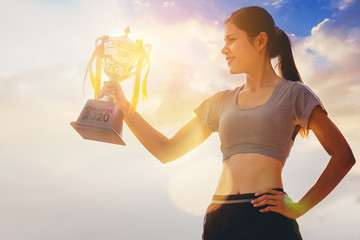 Silhouette woman runner hand holding champion trophy award celebrate her successful. Winning...