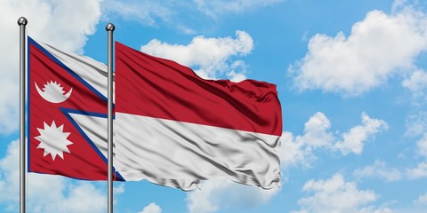 Nepal and Monaco flag waving in the wind against white cloudy blue sky together. Diplomacy concept, international relations.