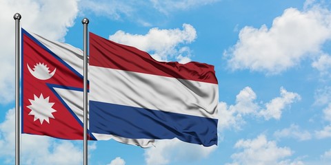 Nepal and Netherlands flag waving in the wind against white cloudy blue sky together. Diplomacy concept, international relations.