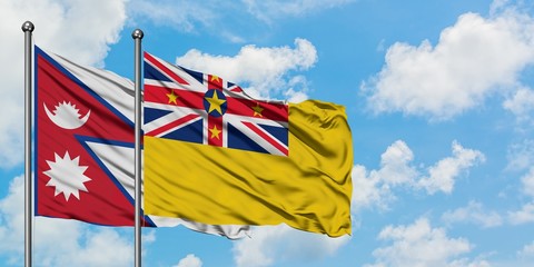 Nepal and Niue flag waving in the wind against white cloudy blue sky together. Diplomacy concept, international relations.