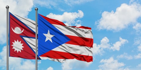 Nepal and Puerto Rico flag waving in the wind against white cloudy blue sky together. Diplomacy concept, international relations.
