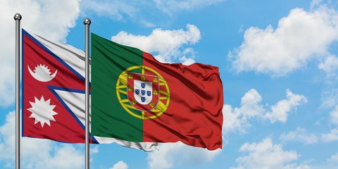 Nepal and Portugal flag waving in the wind against white cloudy blue sky together. Diplomacy concept, international relations.