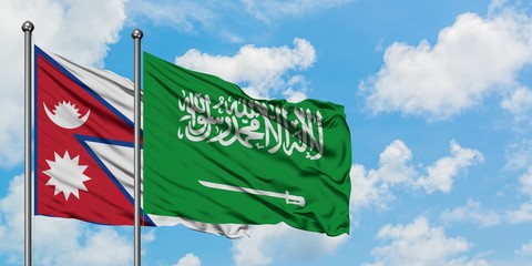 Nepal and Saudi Arabia flag waving in the wind against white cloudy blue sky together. Diplomacy concept, international relations.
